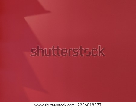 reflection of white bars on a red wall. geometric shadows on the wall.