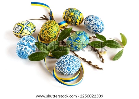 traditional Ukrainian Easter eggs in national colors and in white and blue colors, twigs of willow and periwinkle and a yellow and blue ribbon on a white background Royalty-Free Stock Photo #2256022509