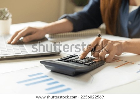 Account finance, asian young business woman hand using calculator, laptop computer for calculate budget, cost and income of company from paperwork, plan spend money expenses, working on desk at home.