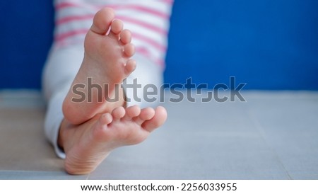 Beautiful bare feet of a child on the floor close up.

