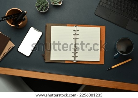 Top view of smart phone, laptop, mouse and cup of coffee on black leather background. Copy space for your text