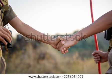 Close-up photo of school boy scouts Handshake with left hand Scout greeting or congratulation Scouts handshake have good teamwork in the camp