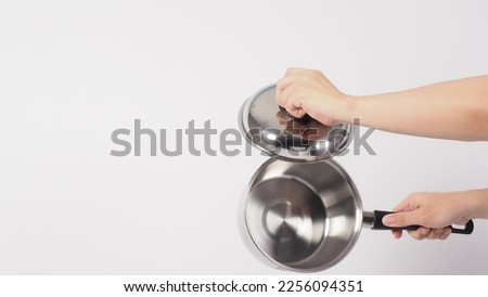 Pot cleaning Man hand on white background cleaning the non stick pot with handy dish washing sponge which yellow color on the soft side and green on hard side for hygiene after cook. Electric pot