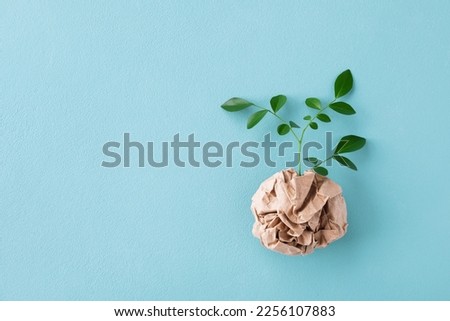Eco concept with green leaves sprout growing from craft paper top view. Plastic free, zero waste, sustainable lifestyle and renewable energy concept. Royalty-Free Stock Photo #2256107883