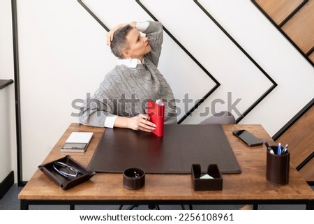 Business woman at workplace looking up dreamily