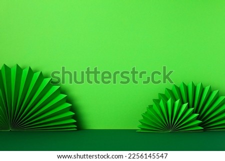 St Patricks Day paper fans on green background. Abstract, minimalist background for Saint Patrick's day banner design.