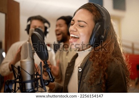 Woman, face or singing on studio microphone with backup singers in album, song or radio recording. Artist, musician or friends and production headphones in sound, voice or media performance for label Royalty-Free Stock Photo #2256154147