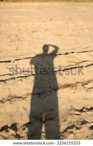 A self-portrait created from the shadow of the photographer falling on the sand