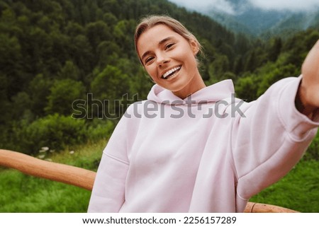 Young white brunette woman smiling and taking selfie photo while walking in forest