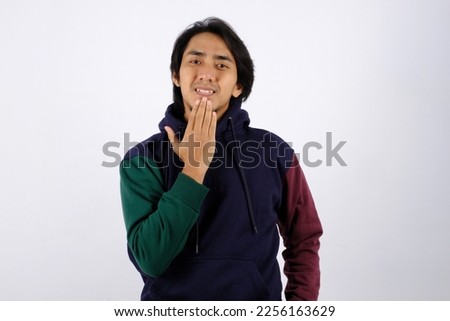 Asian man wearing sweater showing Thank You gesture in sign language on white background