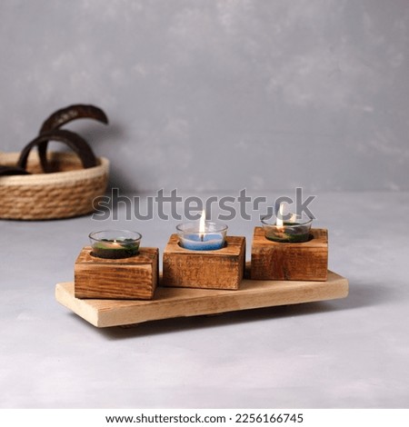 Wooden candle holders on gray floor Royalty-Free Stock Photo #2256166745