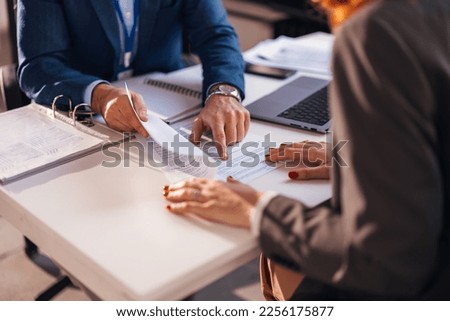 The real estate agent closes the deal with the client and they sign the contract. Royalty-Free Stock Photo #2256175877