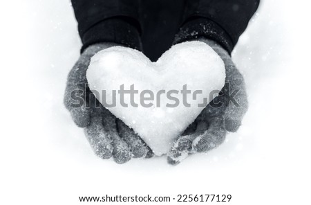 Close-Up of Female Hands Holding a Snow Heart on a Winter Day