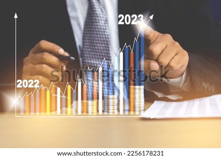Businessman analyze company sales data report increase arrow bar graph corporate future growth year 2022 to 2023. Business Planning, opportunity, challenge and business strategy concept Royalty-Free Stock Photo #2256178231