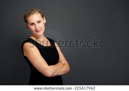 Portrait of a beautiful young business woman standing against grey background