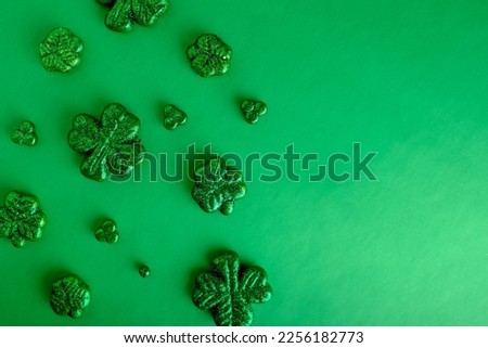 St. Patrick's Day flat lay background with copy space by green glitter clovers for holiday symbol.
