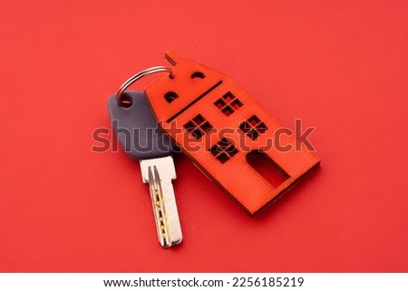 Keys and house keychain. Contract agreement to buy or construction new home, insurance, registration of lease, rent apartments. House key on a house shaped keychain, moving home or renting property.