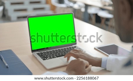 African-American Doctor Working on Laptop with Chroma Key Screen