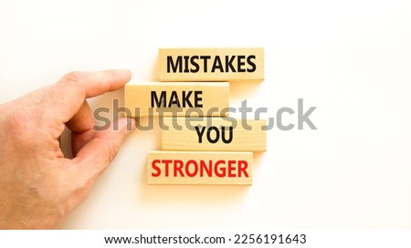 Mistake make stronger symbol. Concept words Mistakes make you stronger on wooden blocks. Beautiful white background. Businessman hand. Business mistake make stronger concept. Copy space.