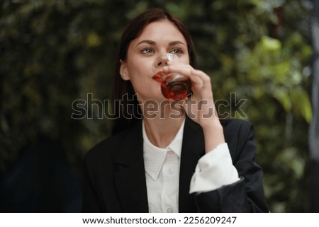  woman with red lips smile with teeth drinking tea in a cafe from a Turkish glass mug on the street, summer travel, vacation in the city Royalty-Free Stock Photo #2256209247