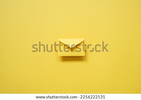 Yellow card envelope on yellow background. top view, copy space, minimalism