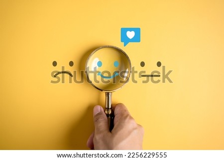 Smile happy face inside of magnifier glass with love icon massge between sad and normal emotion, Positive emotion, Mental health care concept. Royalty-Free Stock Photo #2256229555