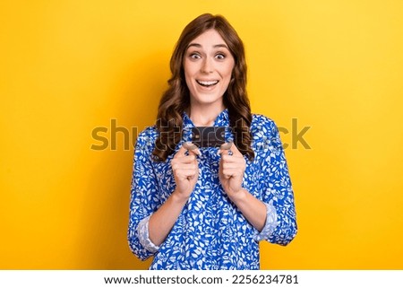Photo of excited funny shopaholic lady wear blue trendy shirt surprised hold premium plastic credit card payment isolated on yellow color background