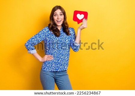 Photo of astonished excited lady freelancer wear trendy clothes hold red card empty space isolated on yellow color background