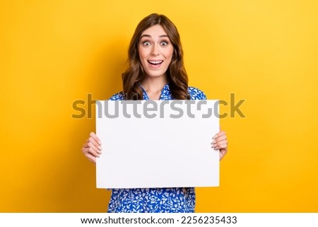 Photo of impressed excited lady wear print shirt showing white billboard empty space isolated yellow color background