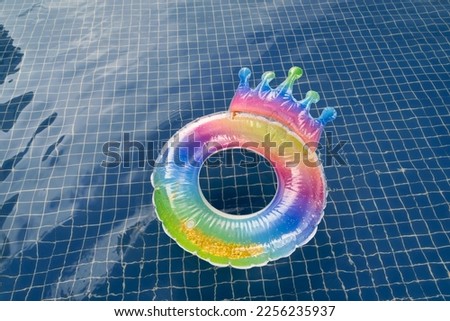 Colorful children's float with golden glitter on top of blue pool water.