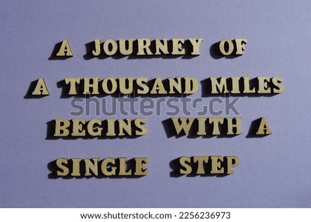 A Journey of a Thousand Miles Begins With a Single Step, motivational words in wooden alphabet letters isolated on background