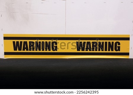 Yellow and black color with line striped label banner with word warning
