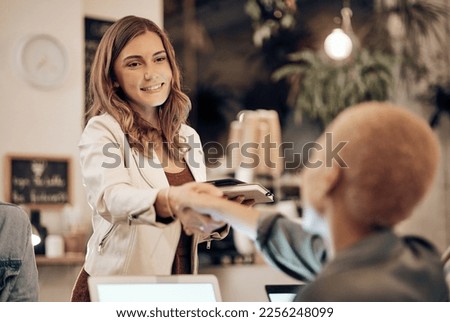 Handshake, coffee shop and service with a woman customer saying thank you to a waitress in a restaurant. Cafe, sale and welcome with a female consumer and small business owner shaking hands Royalty-Free Stock Photo #2256248099