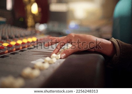 Hands, music mixer and sound board of radio producer, broadcast and scales in studio. DJ equipment, electronic media and switch of audio engineering machine for recording, production and control room