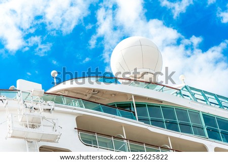Radar, safety and navigation equipment on passenger ship. Cloudy blue sky background.
