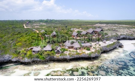 Landscape of the Indian Ocean coastline with at Mtende Beach, Zanzibar. Rocks and white sand. View from the sea