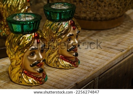 Picture of two candles from Sicily showing the tipical testa di moro in golden colour 