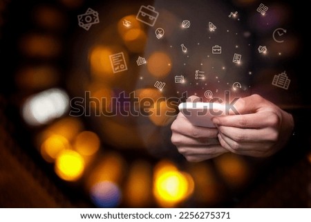 A businessman is doing business using a mobile phone on a dark background.