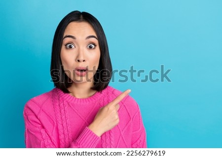 Portrait of impressed speechless filipino lady indicate finger empty space isolated on blue color background