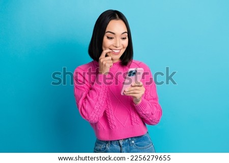Photo of pretty creative cheerful thai person finger touch lips use telephone isolated on blue color background
