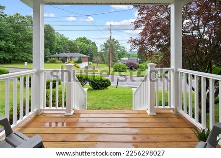 Wooden Porch on Home Looking at Road Royalty-Free Stock Photo #2256298027