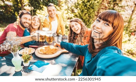 Happy group of friends drinking beer at brewery bar restaurant - Young people having dinner party sitting in pub garden - Life style concept with guys and girls hanging out on summer vacation Royalty-Free Stock Photo #2256301945