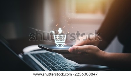 Businessman using a laptop with online shopping concept, marketplace website with virtual interface of online Shopping cart part of the network, Online shopping business with selecting shopping cart. Royalty-Free Stock Photo #2256308847