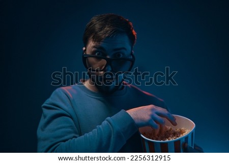Man with surprised expression and popcorn. Emotion while watching a movie. High quality photo