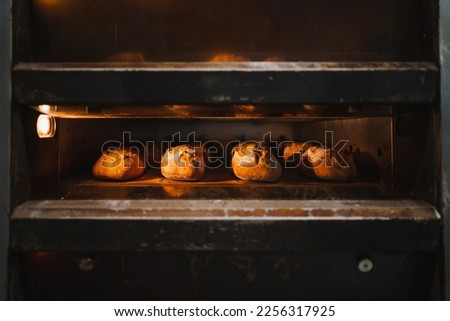 Several artisan breads being baked in a industrial oven