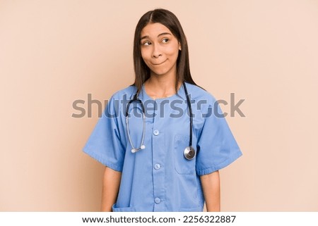 Young nurse colombian woman isolated confused, feels doubtful and unsure.