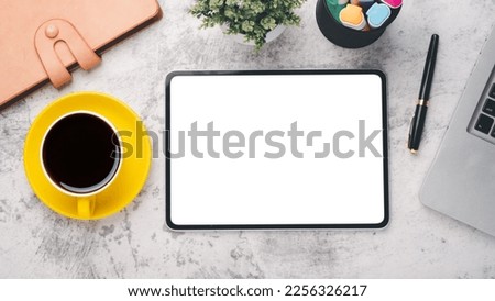 Office desk workplace with blank screen tablet, laptop, pen, notebook and cup of coffee, Top view flat lay.
