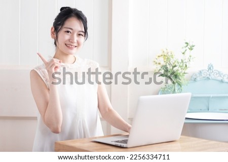 Asian woman using a laptop Royalty-Free Stock Photo #2256334711