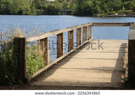 Deck lake, A wooden deck extends out into the Daylesford lake, providing a perfect spot for relaxing and taking in the natural beauty. Whether you're fishing, boating, or simply enjoying the view. Royalty-Free Stock Photo #2256341865