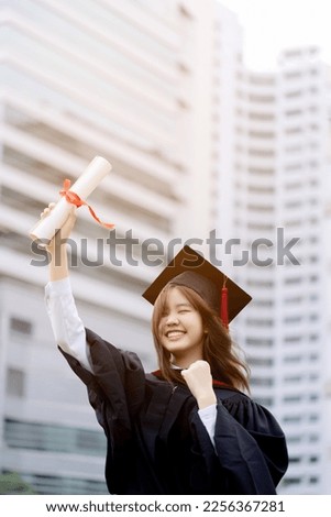 Happy Asian graduations girl showing certificate of diploma from college. Royalty-Free Stock Photo #2256367281